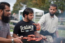 Three Asian men cooking at a BBQ