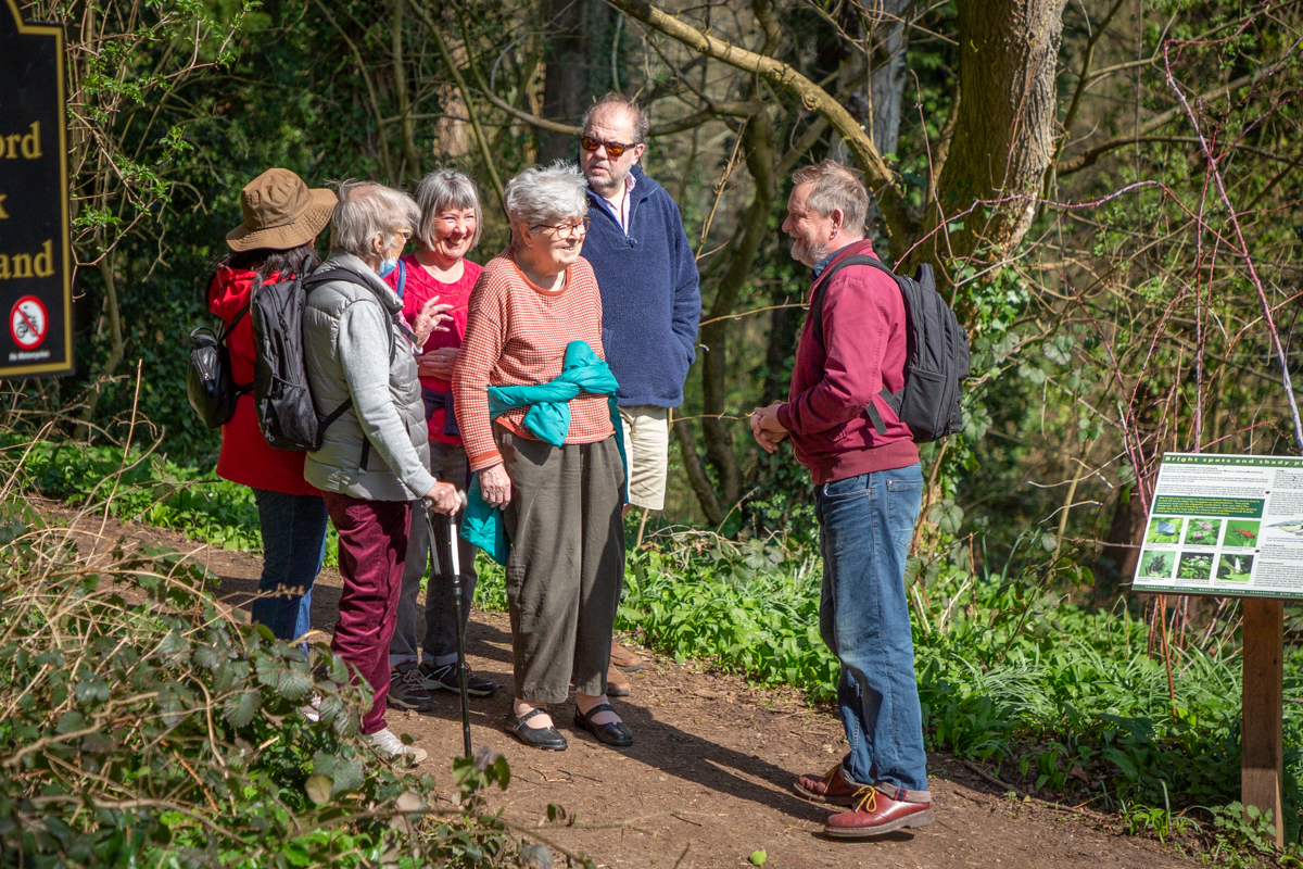 Chris standing and chatting to a group of people on one of the gentle walks.