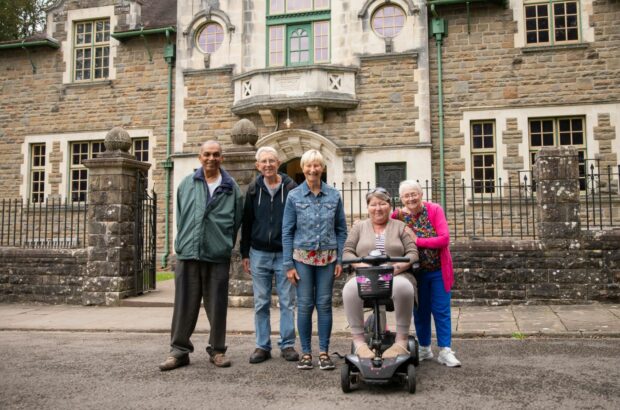 A group of participants stood outside one of the buildings at St Fagans. They're smiling for the camera.