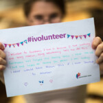 Courtney holding a sign on why she volunteers