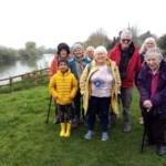 Group photo of Stroud participants. They're standing in a green patch with a river in the background.