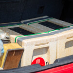Two nuc boxes in a car boot, as well as some general bee keeping equipment.