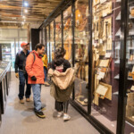 Group of people looking at clothing exhibits.