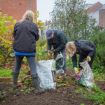 Rachel and two Spirax Sarco volunteers cleaning up the plant bed before it has a new border made.