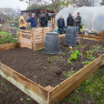 Rachel & Lloyd chatting with the Spirax Sarco volunteers who have just finished remaking the borders of a plant bed.