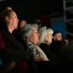 People in the audience watching the performances intently.
