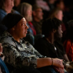 Close up shot of a lady in the audience watching the event.