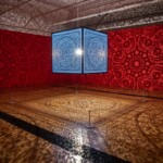 An indoor art display at Kew. There's a cube suspended from the ceiling with a light inside that casts patterned shadows across the rest of the room.