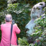 A participant taking a photo of a sculpture at Kew.