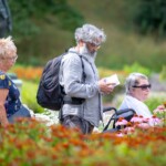 Reyaz and two participants strolling around the gardens, looking at the map.