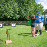Young girl taking aim at a target with her bow and arrow.