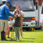 Young girl taking aim at the target as Ashraf instructs her.