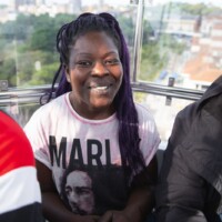 Sylvia smiling and sitting in a cab on an observation wheel.