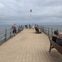 Participants all spread out on a stone pier going into the sea.