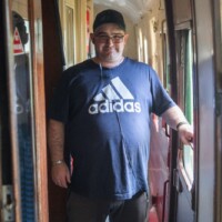 Kev, a participant, smiling in the corridor of the train.