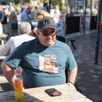 Kev, a participant, sat at a wooden bench on the seafront.