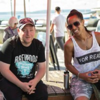Two participants sat on a seaside bench, smiling at the camera.