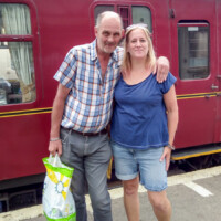 Kevin and Rachel smiling in front of a train.