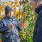 Mr. Patel, a participant, talking with Michael, the farm owner, about apples.