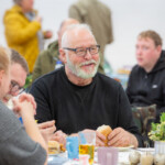 Duncan, a participant, laughing alongside other participants he's sat at the table with.