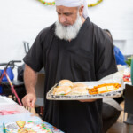 Haroon picking up food from the buffet to take away for people who couldn't make it.