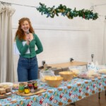 Katie laughing as she gives a speech, standing behind one of the buffet tables.