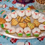 A tray with cookies on, based on snowmen and christmas trees.