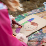 Close up of a child using felt tips to colour a picture of a snail.