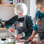 Sue, one of the bakery visitors, cutting an onion using a knife.
