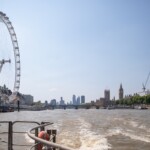 A photo taken from the back of the boat, looking back at the London Eye and Big Ben.