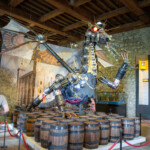 A dragon sculpture inside the armoury of the Tower of London, made up of various weapons and bits of armour.
