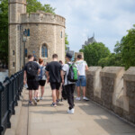 Group of young people walking along the walls of the Tower of London.