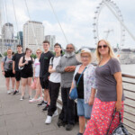 Young people and staff lined up against the bridge railings, smiling for the camera.