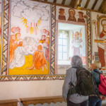 Reyaz and a participant looking at the murals painted on the walls of a church at St Fagans.