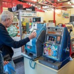 A participant pulling the lever of an old arcade machine at St Fagans.