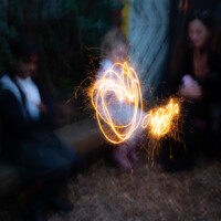 A long exposure of some kids sat down, making wriggly line with their sparklers.