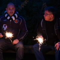 Two visitors sat down holding lit sparklers.