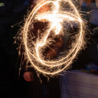 A long exposure of someone moving a sparkler around, creating a series of circles.